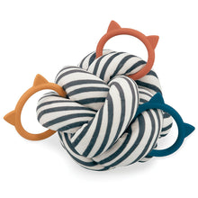 A large sensory ball with intertwined stripes and cat-shaped silicone teething rings in black, white, and orange colors.