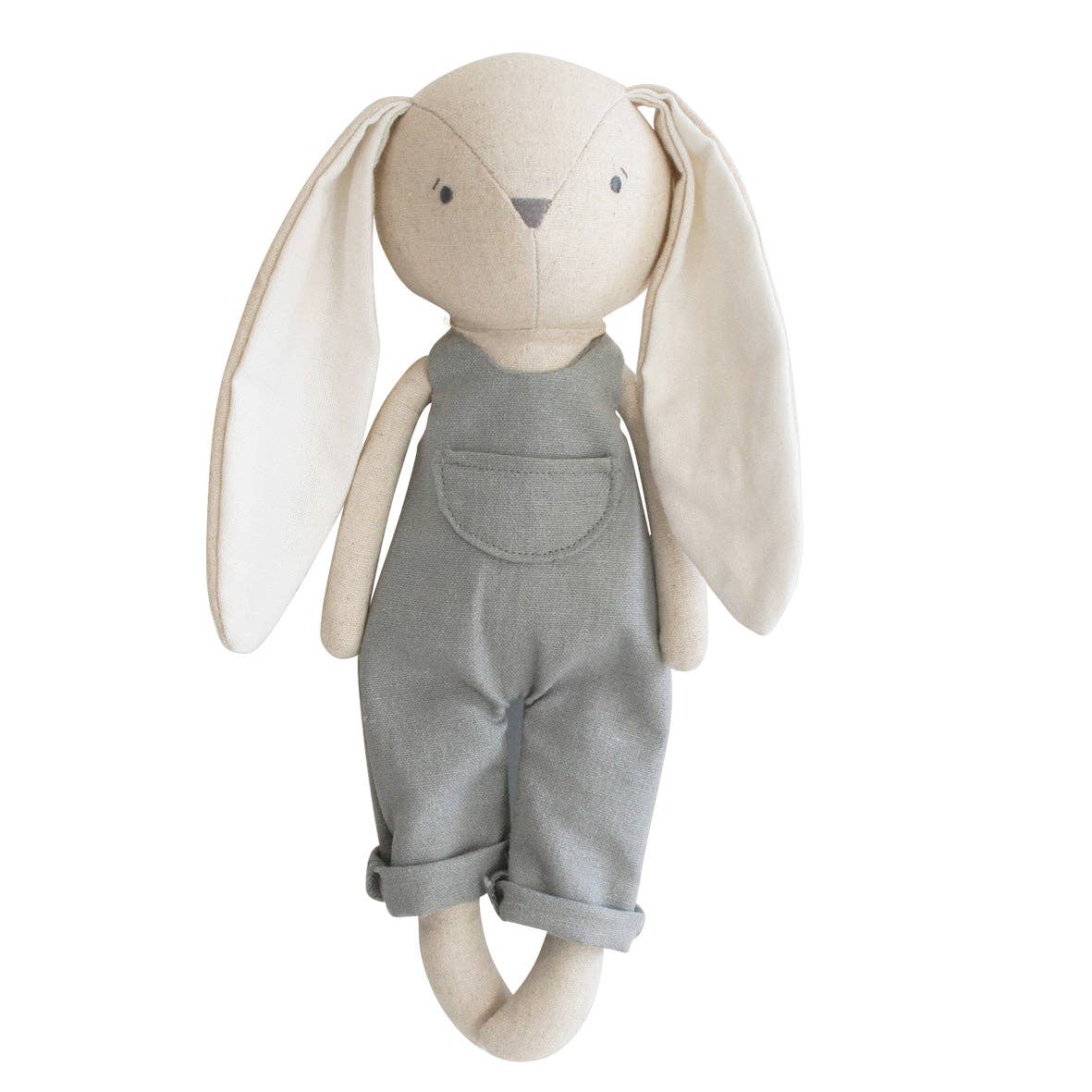 A grey and beige cotton-linen fabric stuffed bunny with embroidered face, dressed in overalls, standing upright.