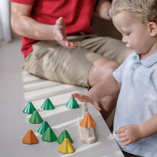 Child playing with colorful wooden geometric shapes on a table