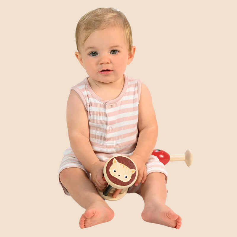 Cute baby holding Mentari brand wooden cat rattle