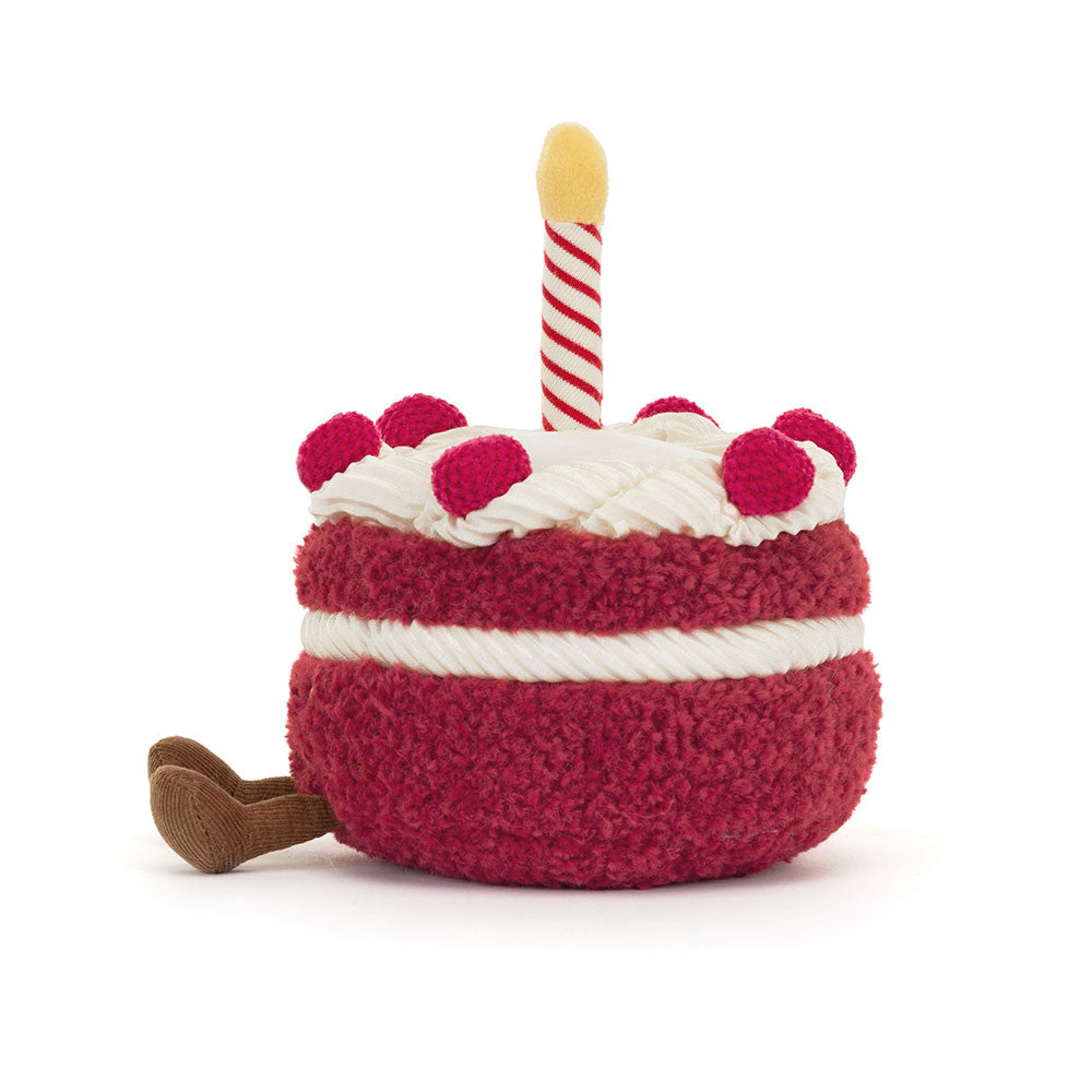 Toy resembling a birthday cake with a candle on a white background
