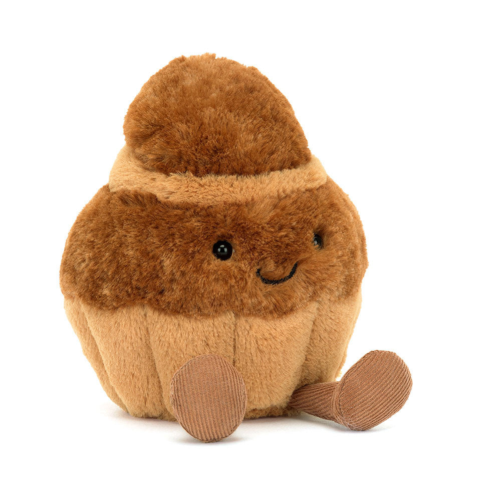 Plush toy resembling a brown cupcake with a smiling face on a white background
