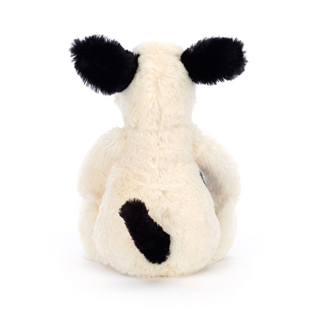 Cream dog plush toy with black accents on a white background