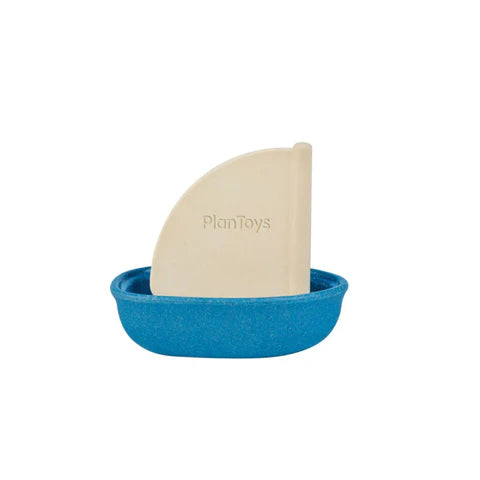 A small blue wooden sailing boat with white rubber mast. The mast is printed with the word PlanToys.