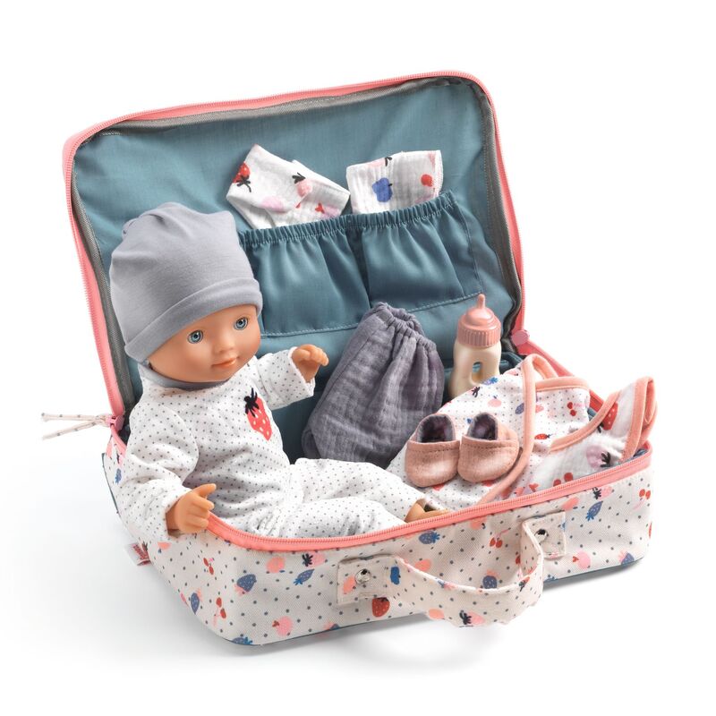 Toy doll with accessories in a travel bag on a white background