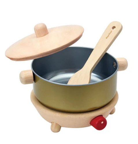 Children's toy kitchen set with a pot, lid, and wooden spoon on a white background