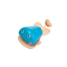 Wooden toy fish castanet with a blue body and wooden fins on a white background