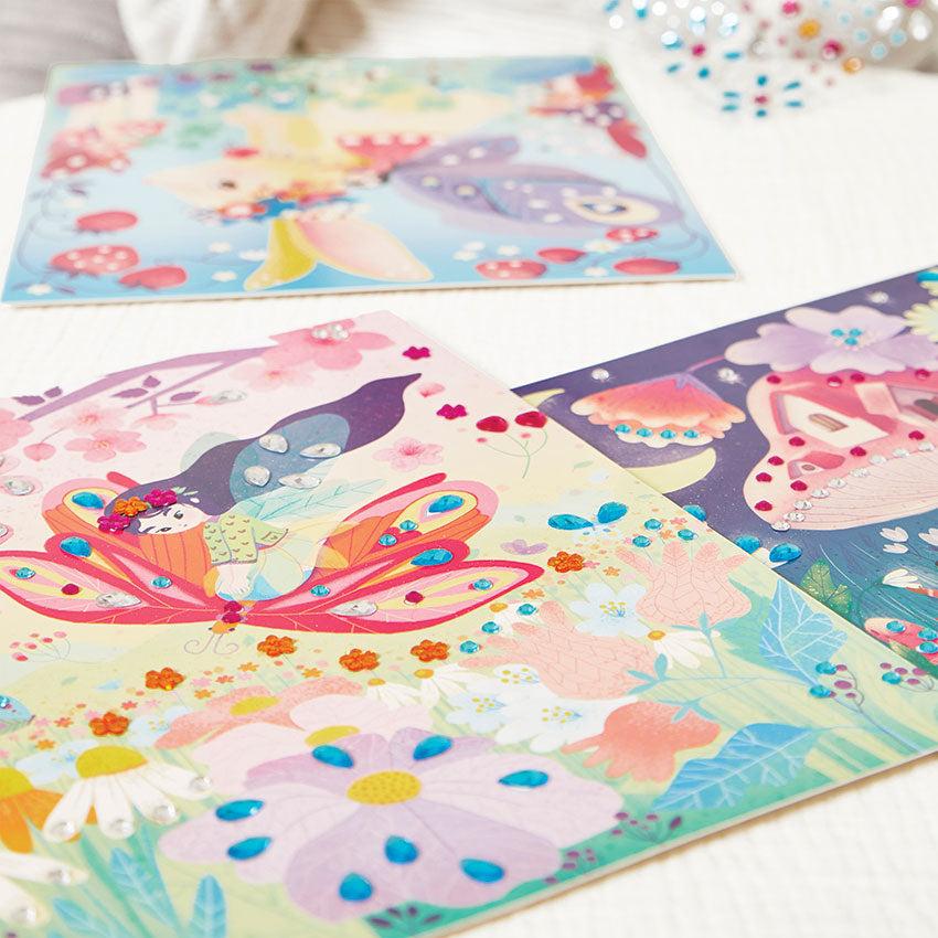 Colorful butterfly-themed jewel stickers on a white surface with additional stickers in the background.