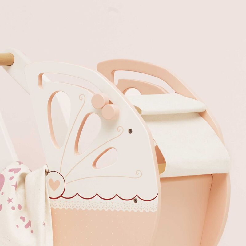 decorative elements on a light pink doll pram toy