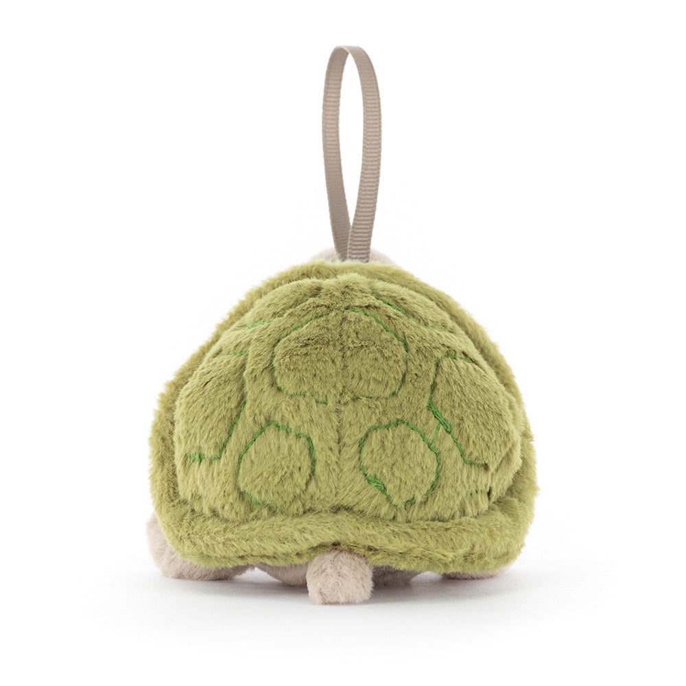 Green plush soft toy resemblinnbg a turtle with a hanging strap on a white background