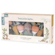 Moulin Roty 'Trois Petits Lapins' Musical Mobile packaging, featuring a window display with a gray hedgehog toy and soft pastel-colored hanging garden.