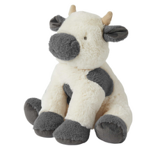 Grey and cream cow plush toy on a white background