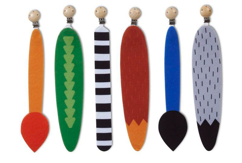 Set of colorful wooden clips with felt animal tail shapes attached on a white background