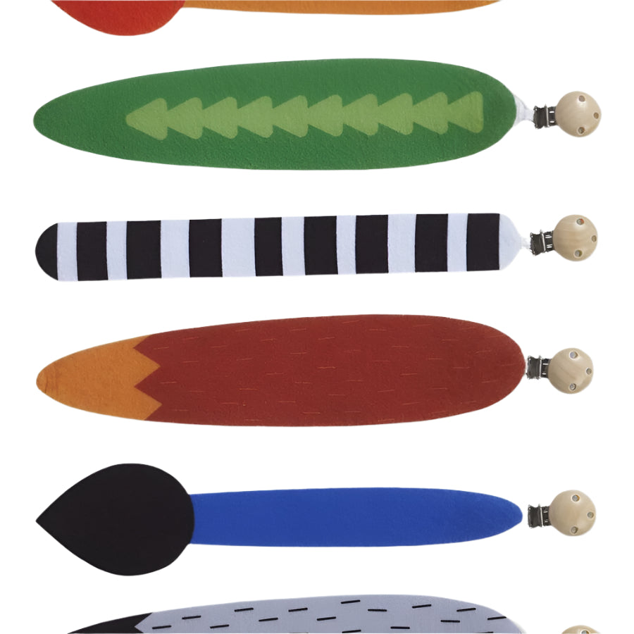 Colorful felt animal tails with different patterns and wooden clips, on a white background