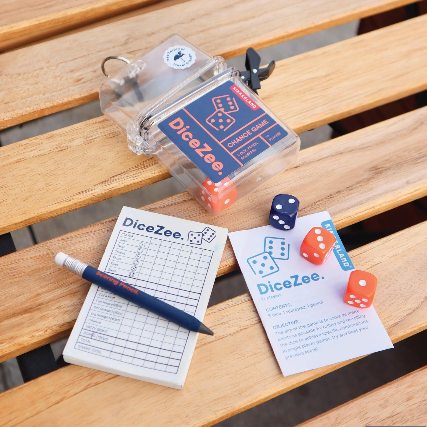 DiceZee game components including dice, score sheet, and pen on a wooden surface