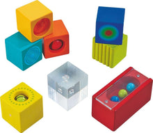 A set of colorful wooden blocks, each with a different sound effect or visual feature designed for toddler learning and play.