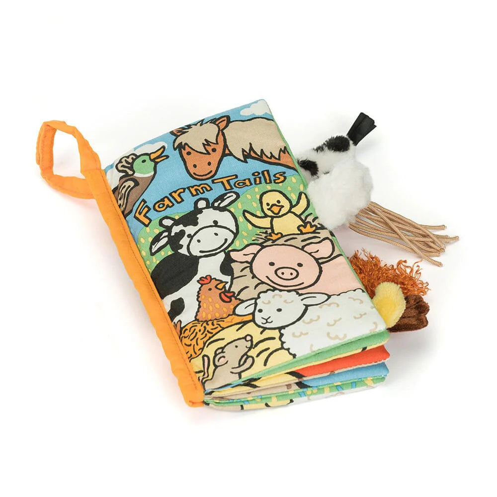 A padded fabric book printed with smiling farm animals. Padded animal tails are sticking out the side of the book.