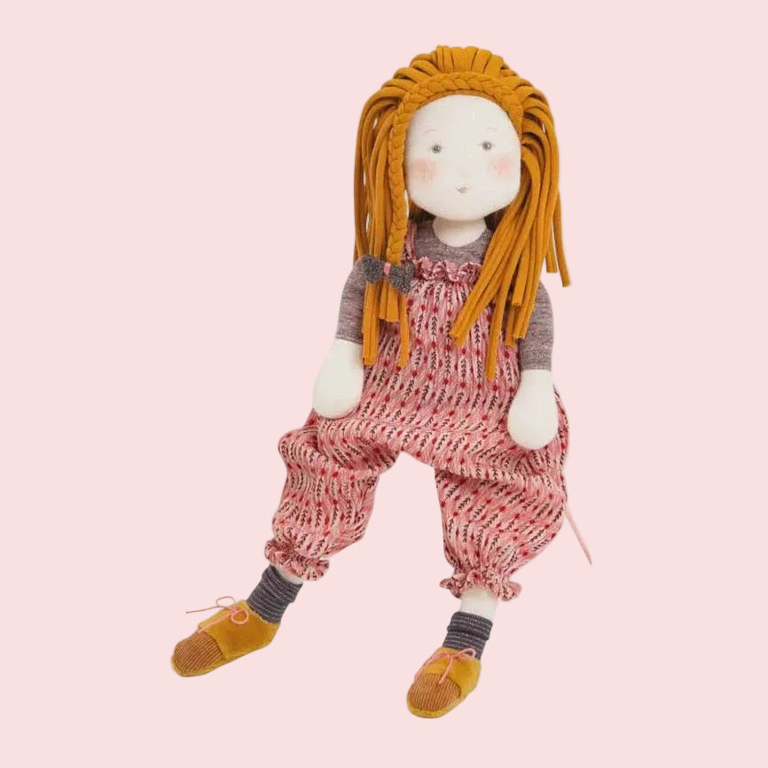 Doll with long orange hair wearing a knitted outfit on a white background