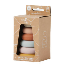 Charli Silicone Round Stacker toy in various soft colors packaged in a cardboard box with a clear window showing the stackable rings.