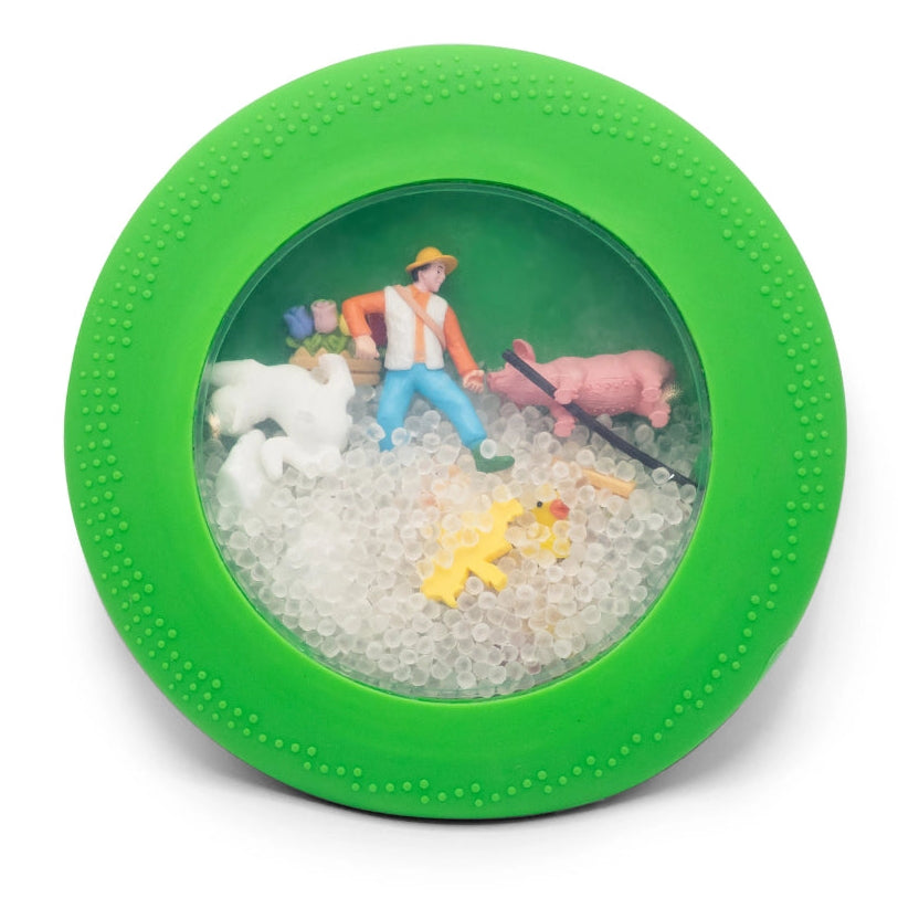 Green toy with a miniature scene of a person with animals on a white background