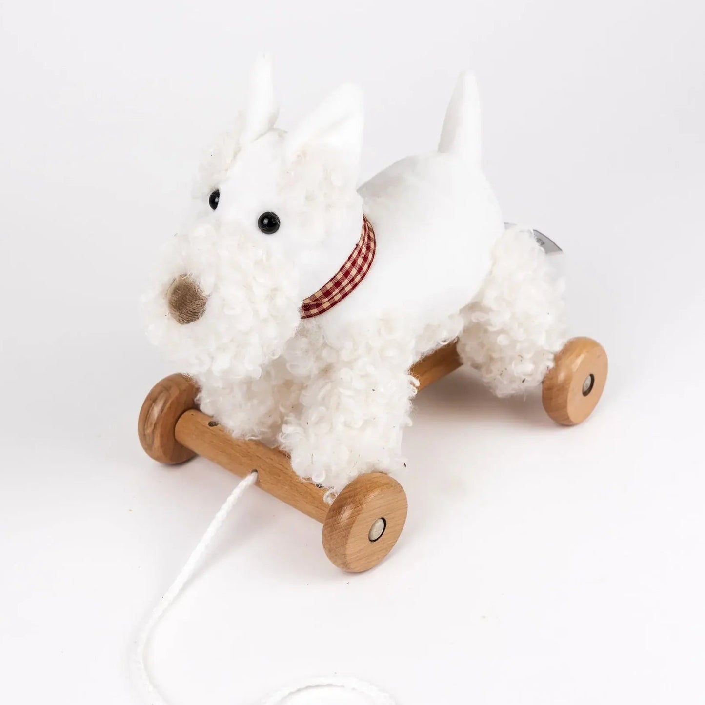 White plush dog toy with wooden wheels on a white background