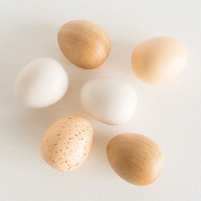 Wooden toy eggs on a white background