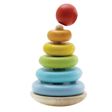 A wooden stacking toy with a series of colorful rings on a wobbly base, with a red ball on top.