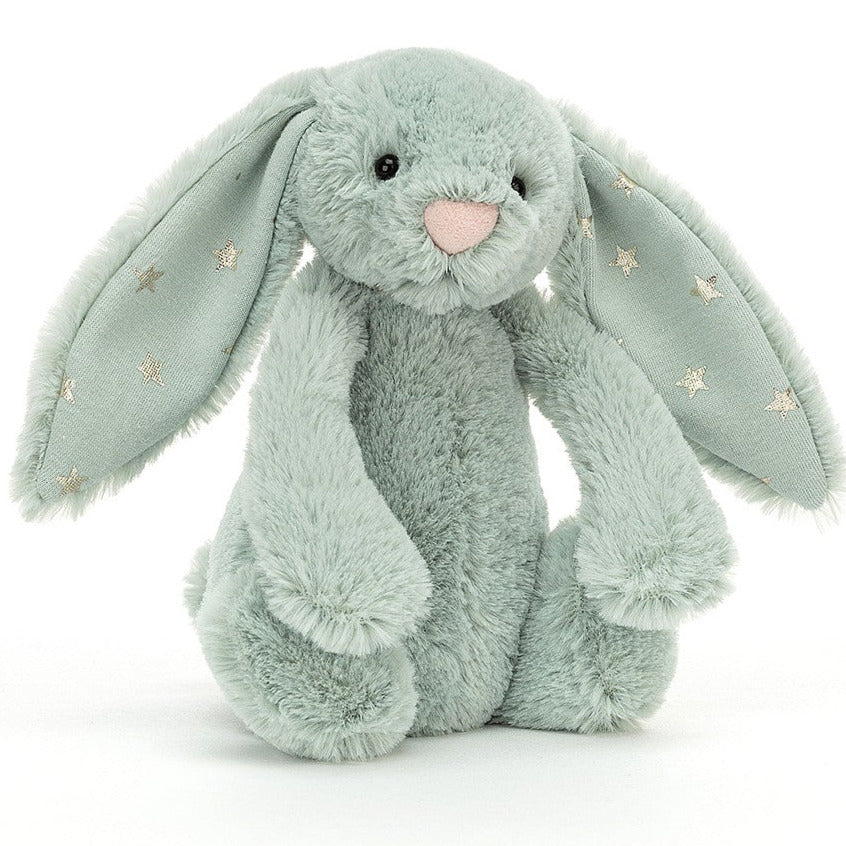 A sage green bunny plush toy with silver stars on its ears, on a white background.