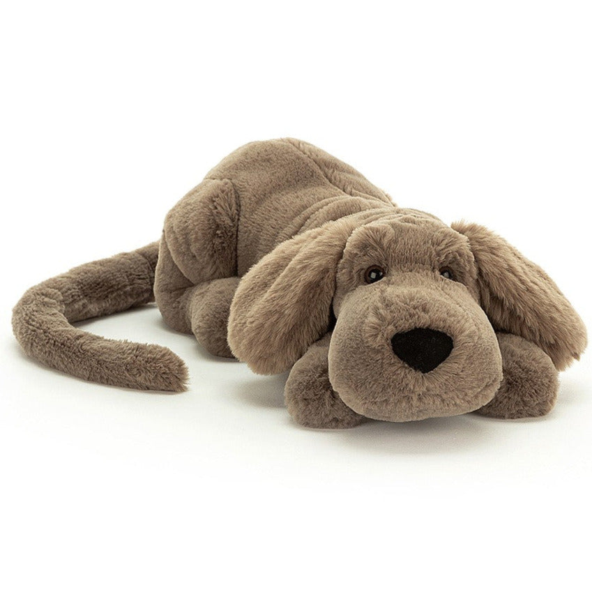 A brown dog soft toy with black nose, pictured lying flat on a white background.