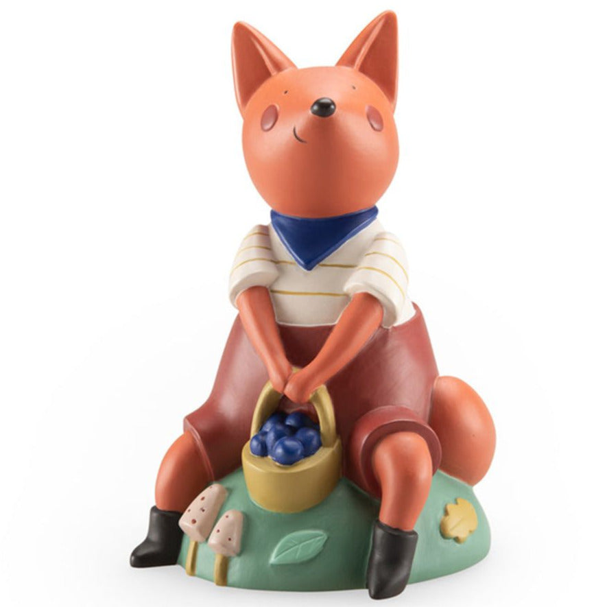 A resin money box figurine of a squirrel wearing a shirt and holding a basket with berries, seated on a round base that features mushrooms.