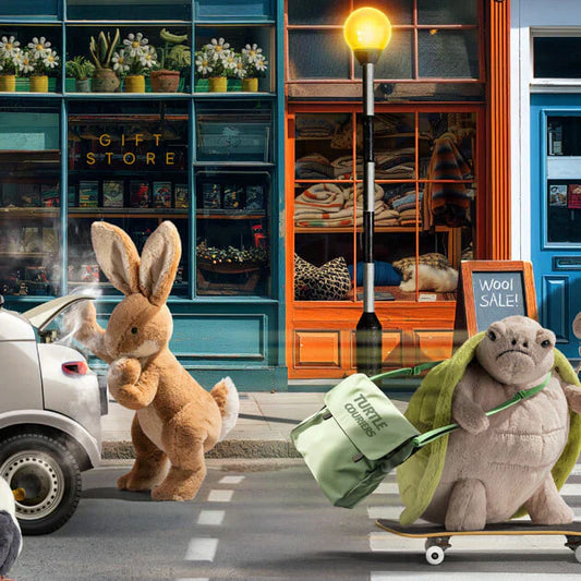 Jellycat hare soft toy loading a car boot, turtle plush animal on a skateboard with boutique shops in the background