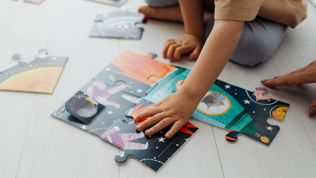 Child completing a large format jigsaw puzzle on the floor.