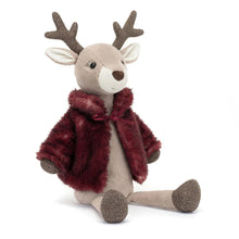 A plush toy depicting a reindeer with a textured berry coat, antlers, and sparkling mocha hooves, wearing a red beret and a red coat with a satin lining.