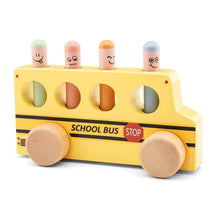 A wooden pop-up school bus toy with colorful figures of a bus driver and passengers.