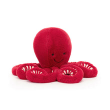 A red plush toy resembling a cranberry octopus with a smiling face and white curly tentacles.