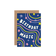 A mini greeting card with a dark blue background featuring the hand-lettered phrase 'Birthday Magic' surrounded by colorful illustrated stars. It comes with a brown envelope.