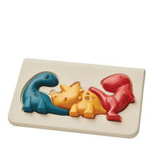 A colorful dinosaur puzzle with interlocking pieces in blue, yellow, and red, set against a beige background.