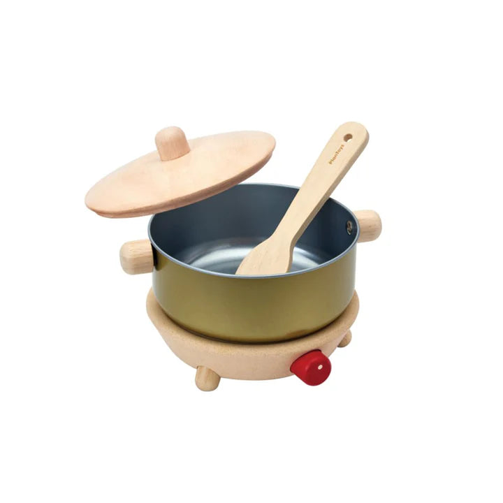 Children's toy kitchen set with pot, lid, wooden spoon, and hot plate on a white background