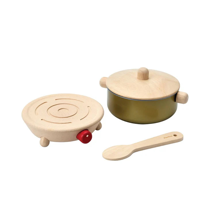 Wooden toy cookware set with pot, burner, and spoon on a white background