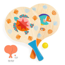 Two wooden beach rackets with colorful sea creature illustrations, a yellow ball, and a storage bag.