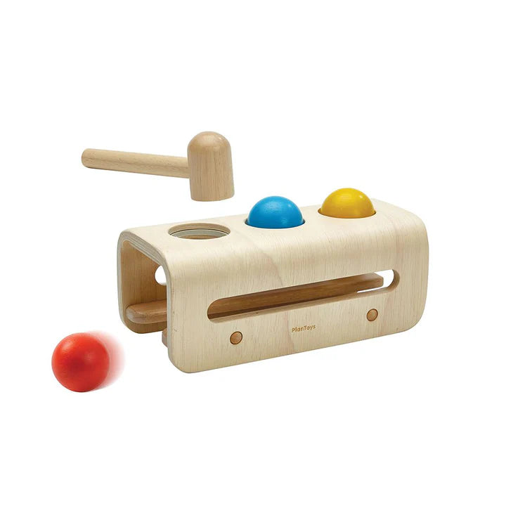 Wooden toy with colorful balls and a mallet on a white background