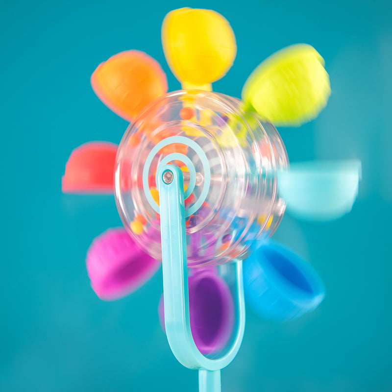 A colorful toy resembling a flower with a spinning wheel in the center and petals in various colors, designed for water play.