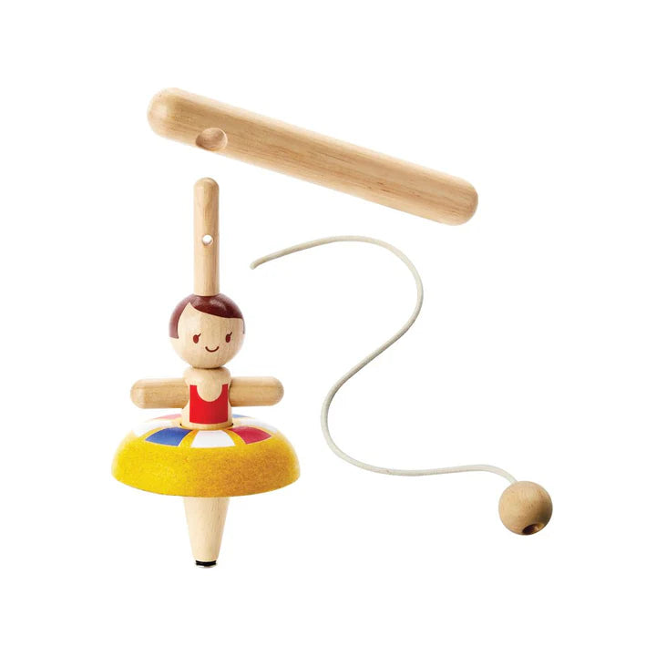 Wooden toy with a character on a colorful platform, attached to a string with a small ball at the end, on a white background.