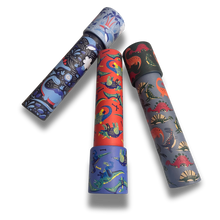 A set of three dinosaur-themed kaleidoscopes in blue, red, and gray, each with various illustrated dinosaurs on the exterior.