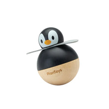 Wooden penguin toy with black and beige body on a white background
