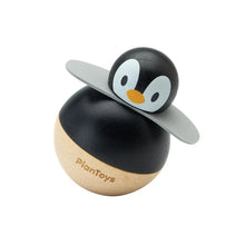 Penguin-shaped toy with black and brown body on a white background
