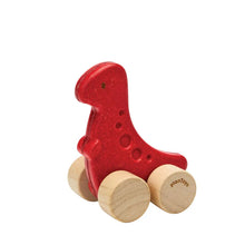 Red wooden toy dinosaur with wheels on a white background