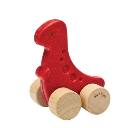 Red wooden toy dinosaur with wheels on a white background