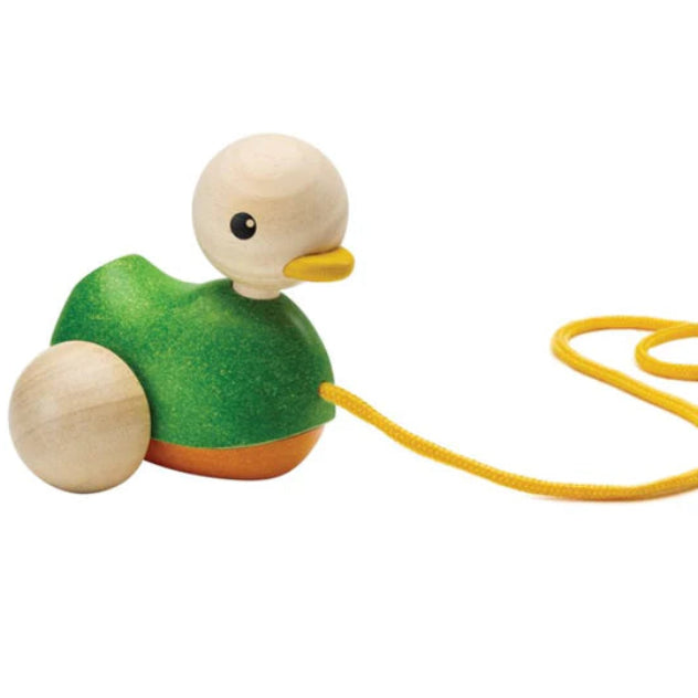 Wooden toy duck with a yellow string on a white background