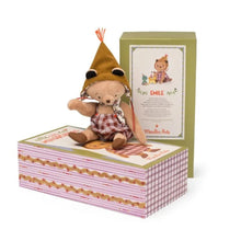 A small articulated bear doll named Emile, wearing a hat and a plaid shirt, positioned next to its beautifully illustrated gift box.